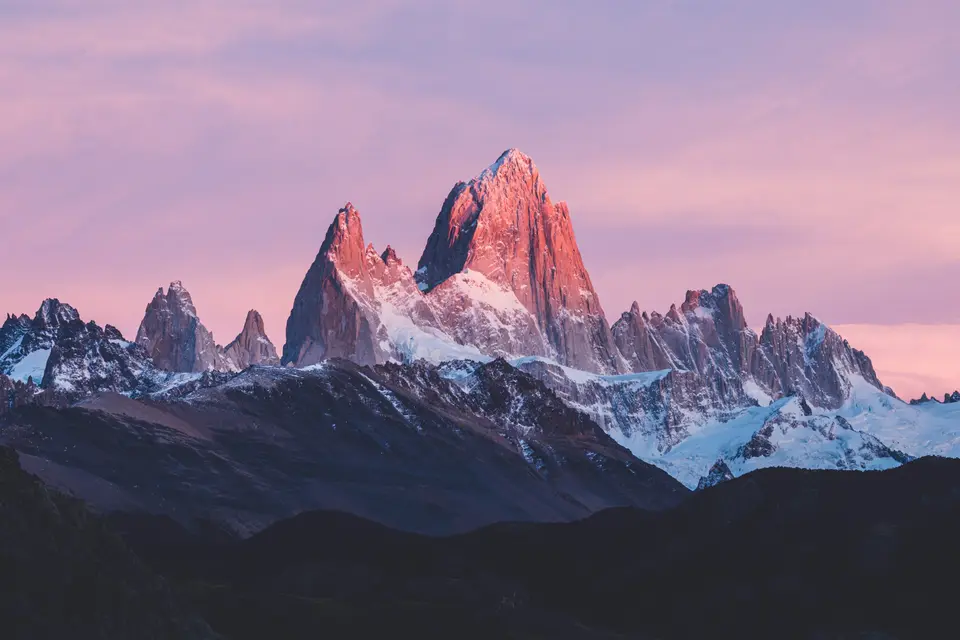 a mountain range with a pink sky in the background — El Chaltén
