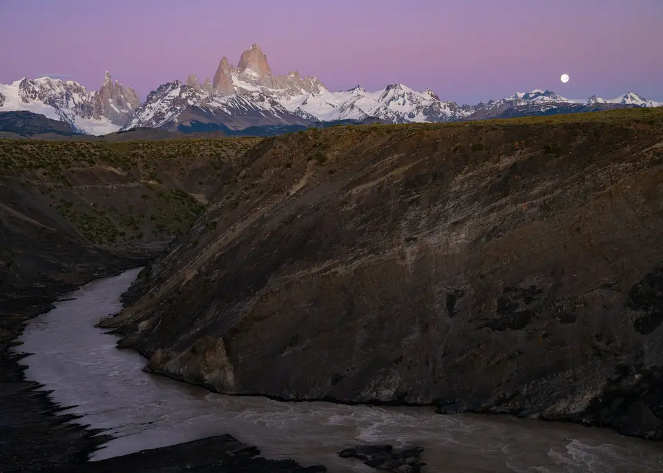 River flows through canyon with moonlit mountains at dusk — El Chaltén