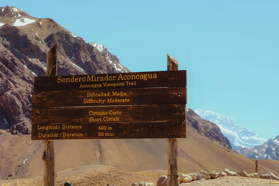 Wooden sign for aconcagua viewpoint trail with mountains — Mendoza