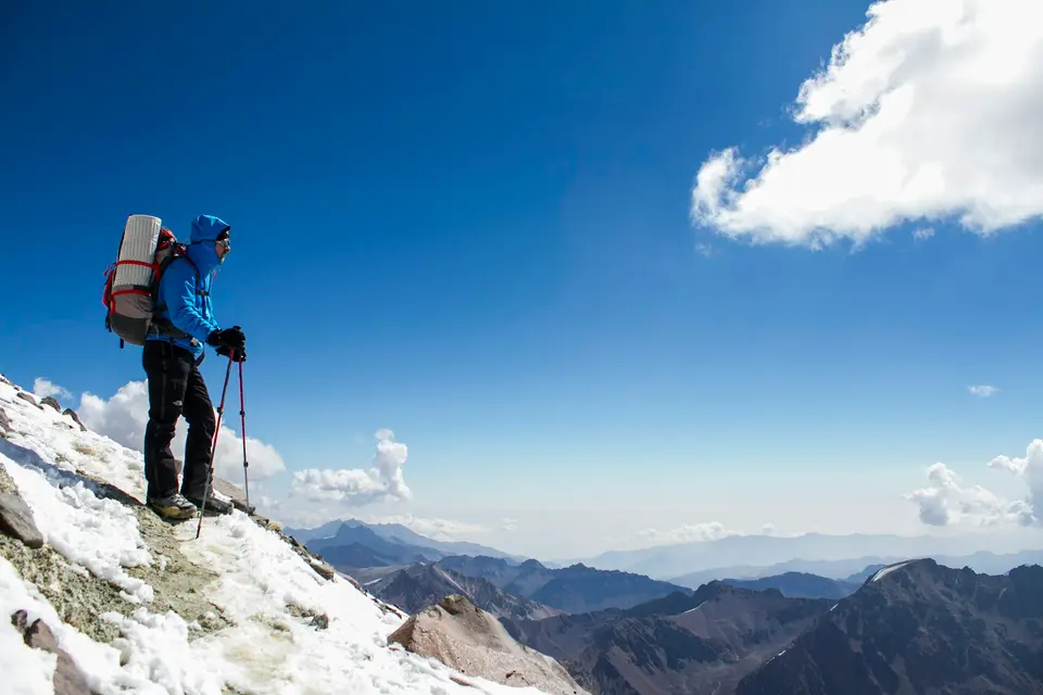 A man with a backpack is hiking up a snowy mountain — Mendoza