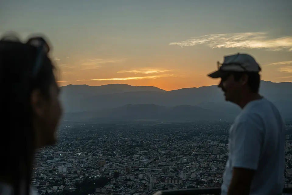 Couple watching sunset over cityscape and city and mountains — Salta