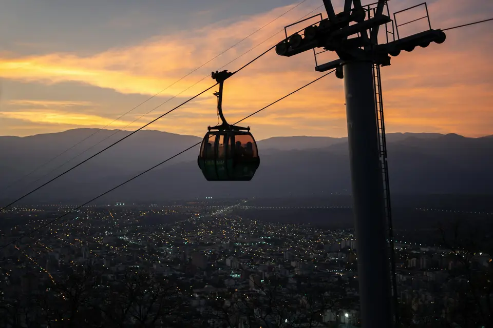 Cable car ascending over city at sunset — Salta