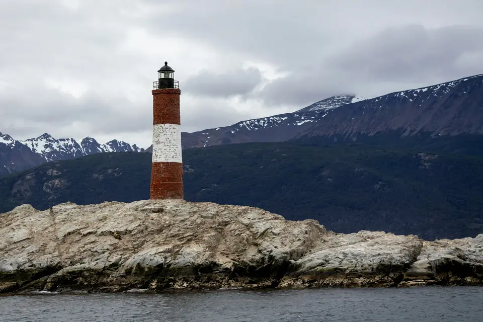 A red and white lighthouse on a rocky island — Ushuaia