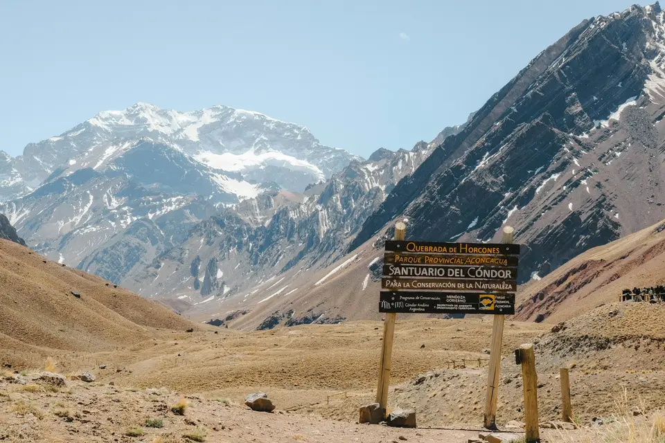 Wooden signpost in a mountain valley with snowy peaks — Valle de Uco