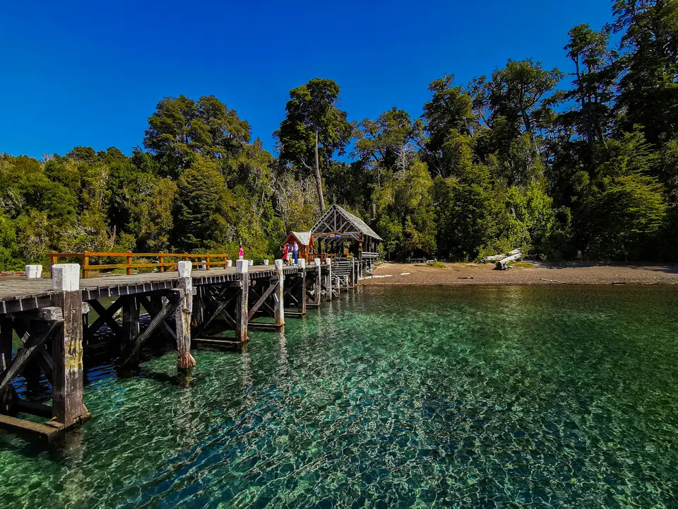 a wooden pier with a small hut on top of it — Villa La Angostura