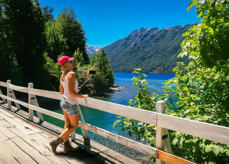 woman in white bikini standing on wooden bridge during daytime — Villa La Angostura