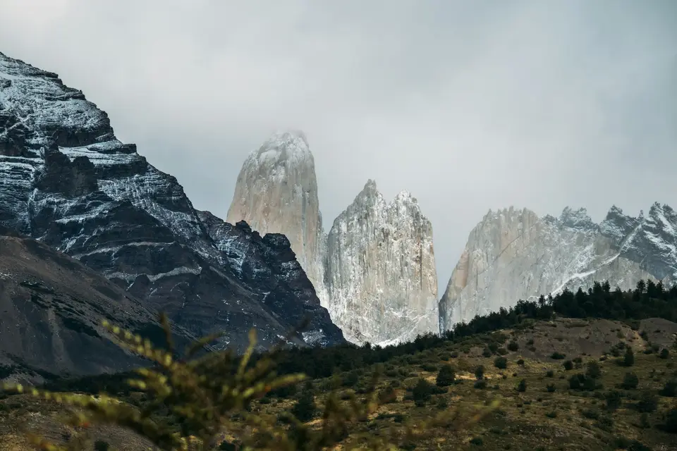 Snow-capped mountains and rocky peaks under cloudy sky